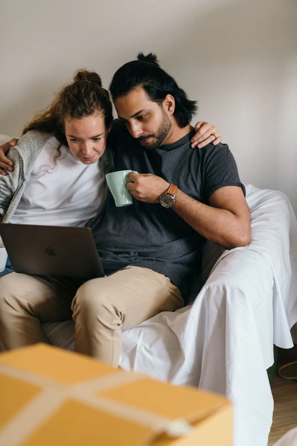 Dua orang melihat laptop bersama di rumah; foto ilustrasi